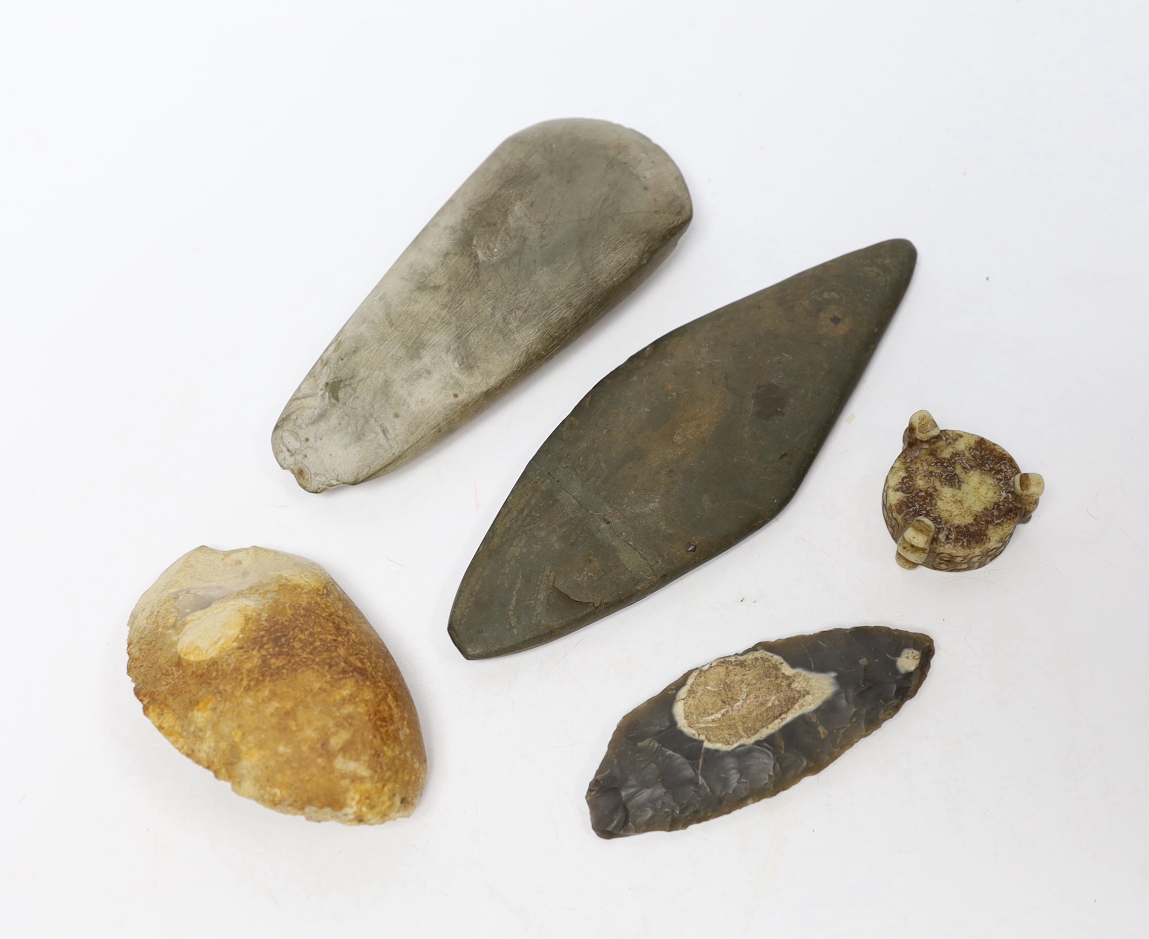 A collection of stone handtools and a Chinese hardstone carving, largest 19cm in length